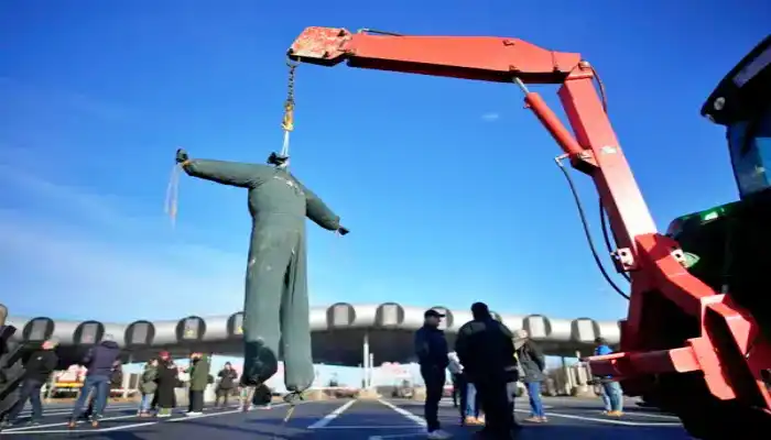 Una efigie de un granjero ahorcado se ve en un peaje de la autopista, el viernes 26 de enero de 2024 en Saint-Arnoult, al sur de París. Los agricultores que protestaban cerraron largos tramos de algunas de las principales autopistas de Francia el viernes, utilizando sus tractores para bloquear y ralentizar el tráfico y presionar al gobierno cada vez más para que ceda a sus demandas de que el cultivo y la cría de alimentos sean más fáciles y lucrativos. (AP Foto/Christophe Ena)