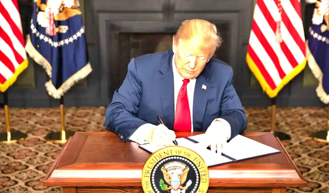 Donald Trump firmando su política arancelaria