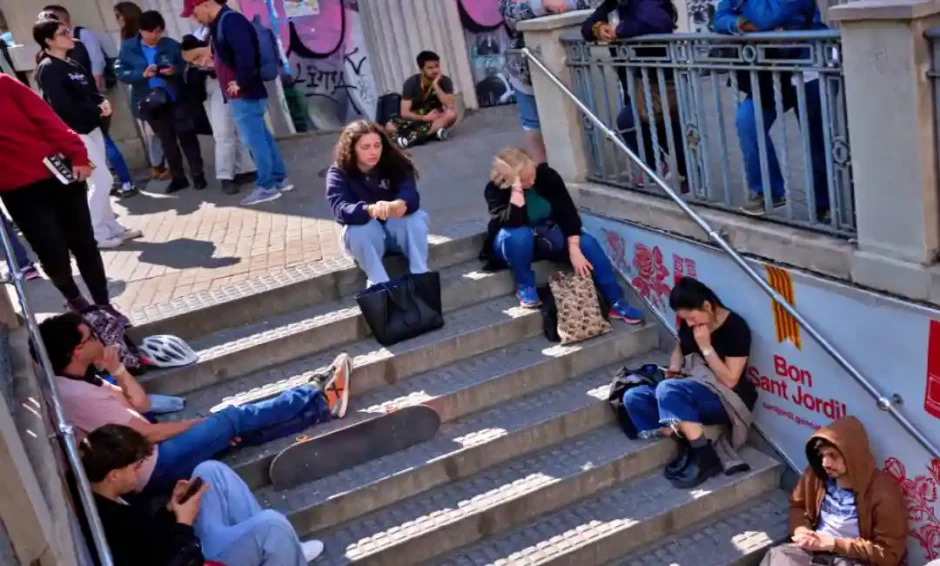 La gente espera fuera de una estación de metro cerrada, durante un gran apagón en Barcelona, España, el lunes 28 de abril de 2025. [AP Photo/Emilio Morenatti]