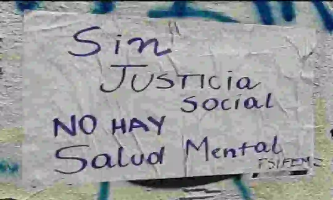 Pancarta colgada en una verja sobre justicia social y bienestar